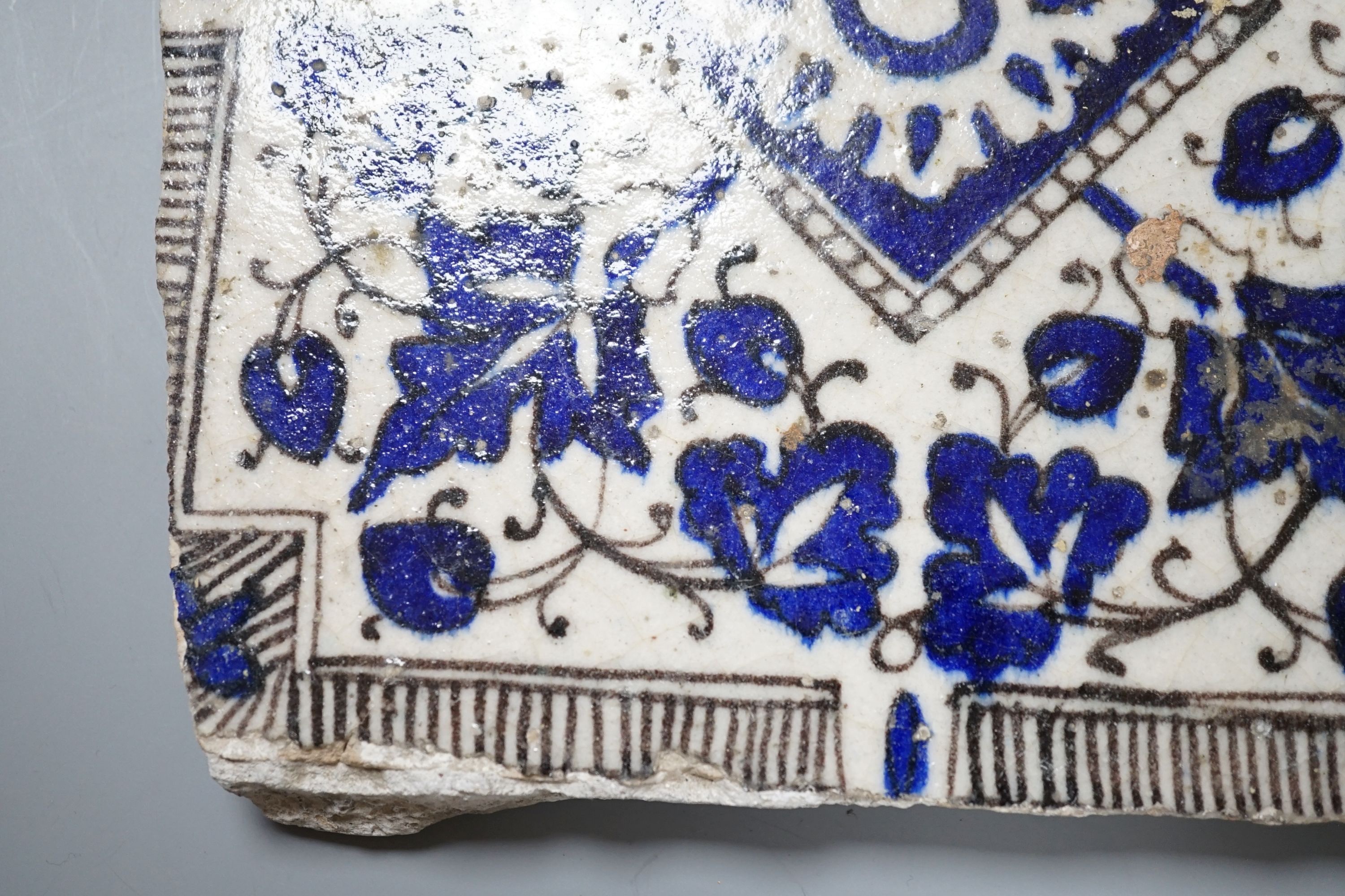 A Persian blue and white ceramic tile - 21 x 20cm